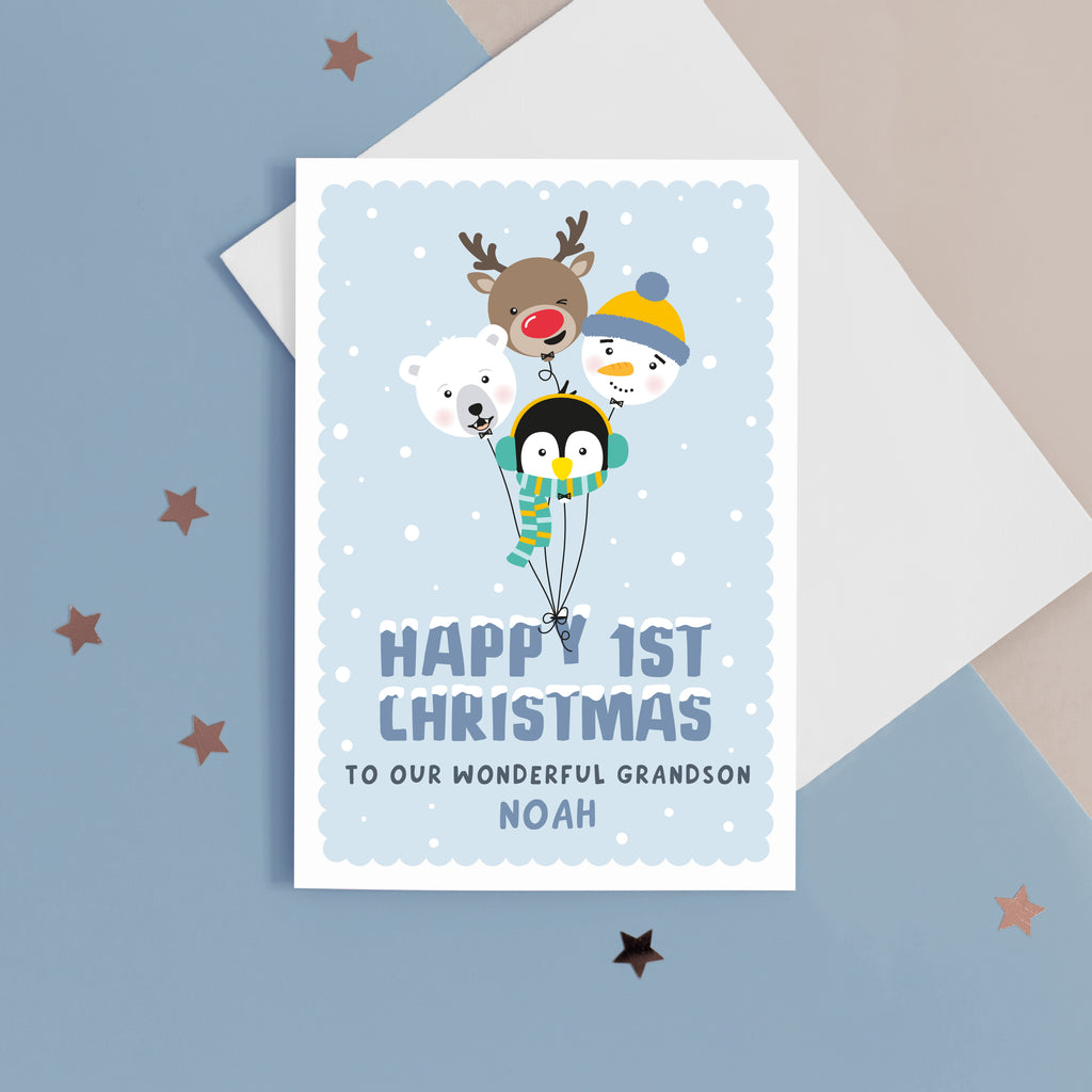 A super cute Christmas card featuring a bunch of happy balloon animals - reindeer, polar bear, penguin and snowman on a soft blue background. Featuring the words Happy 1st Christmas with a space for personalising the card for a special recipient.