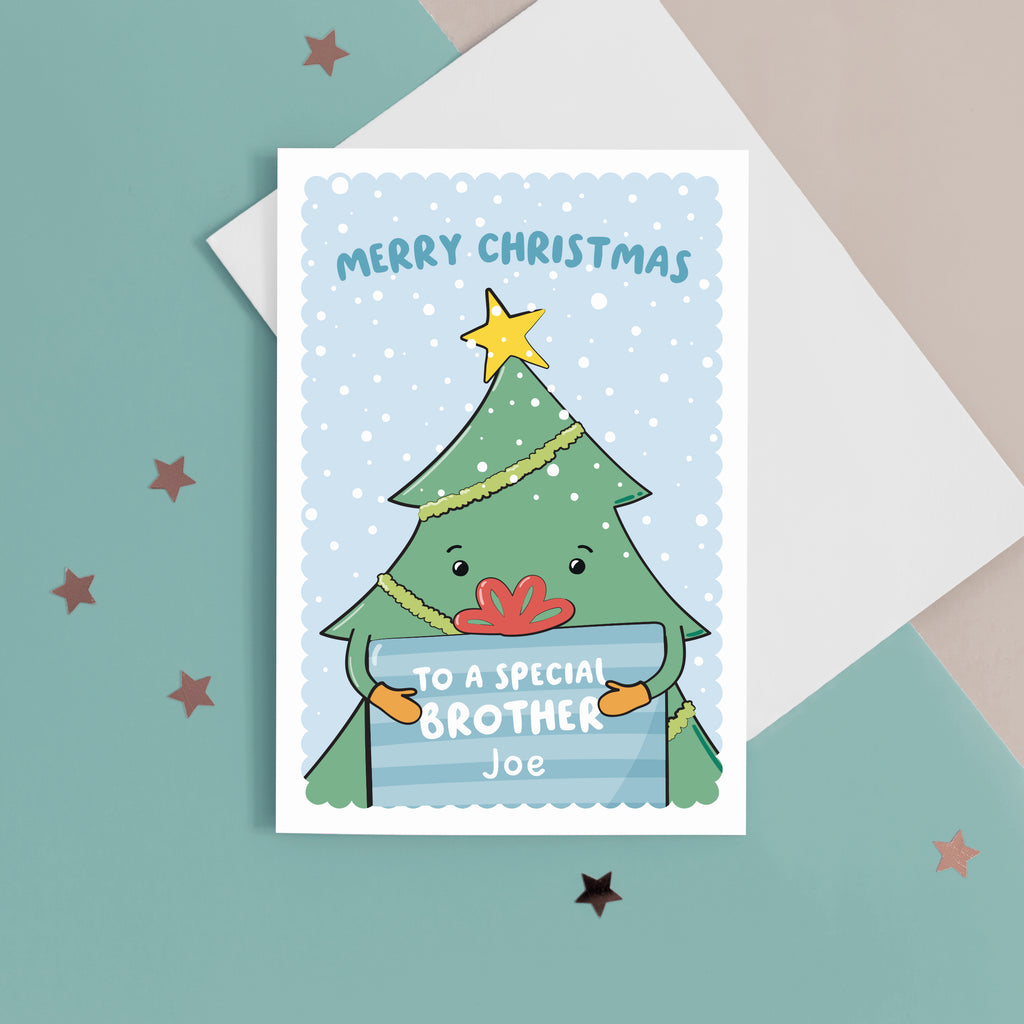 A cute Christmas card with a blue background, featuring a Christmas tree holding a present with a sprinkling of snow. The card reads Merry Christmas to a special Brother with space to personalise with a name.