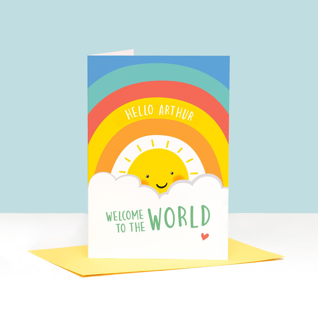 Sun, clouds and colourful rainbow on this card with the words Hello, welcome to the world. Includes any personalised name