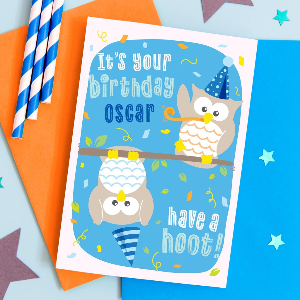 It's your birthday, have a hoot! Blue birthday card with two owls with party hats and streamers. This fun card is personalised with any name.