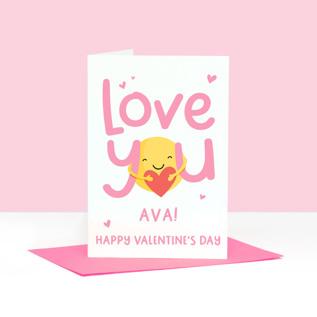 A super cute valentines card with the words 'love you' in pink and featuring a sunshine hug holding a heart. This card can be personalised with a name.