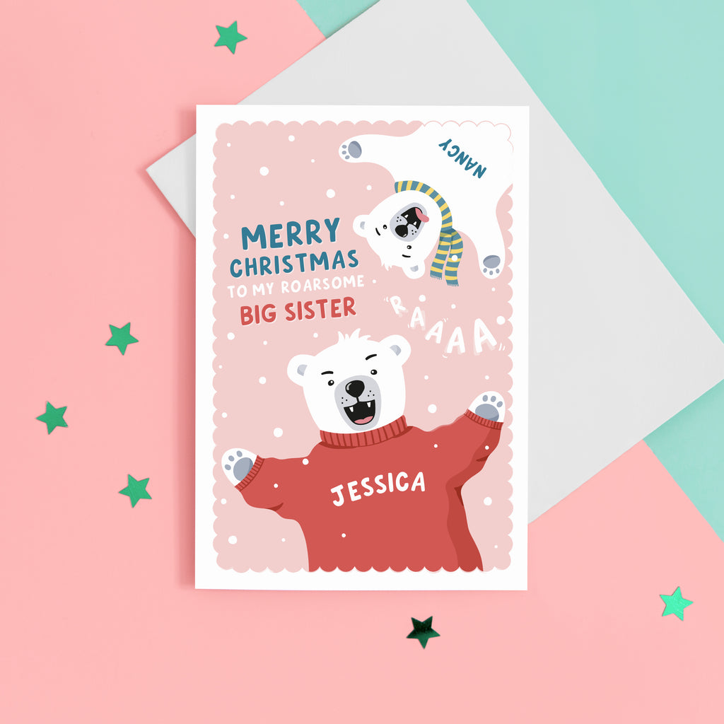 A fun Christmas card featuring two polar bears on a pink snowy background. The card reads ‘Merry Christmas to my roarsome big Sister’. The polar bears can be personalised with names to represent siblings. 