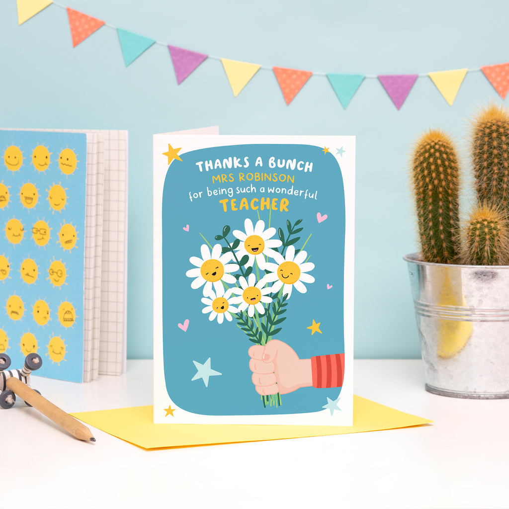 A colourful and cute card featuring a child’s hand (fair skin) holding a bunch of happy flowers. The card reads ‘thanks a bunch (teachers name) for being such a wonderful teacher’.