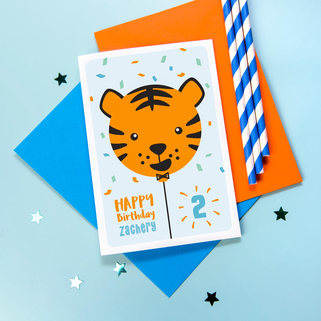 Happy birthday card with cute baby tiger face on a balloon and any personalised name and age.