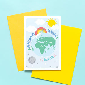 Greetings card with smiling earth character plus sun, moon and rainbow. text says welcome to the world and includes any personalised name in turquoise