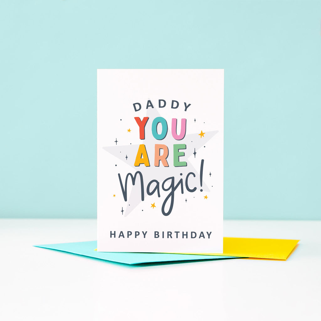 Daddy you are magic Happy Birthday. This bright and colourful typographic card features stars and bold text.