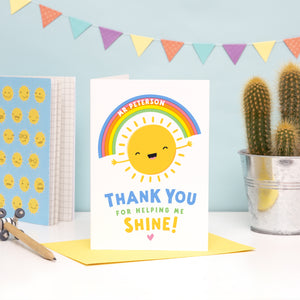 A fun and colourful card featuring a happy sunshine and rainbow with the words 'thank you for helping me shine'. The card can be personalised with the teacher / teaching assistants name on the rainbow.