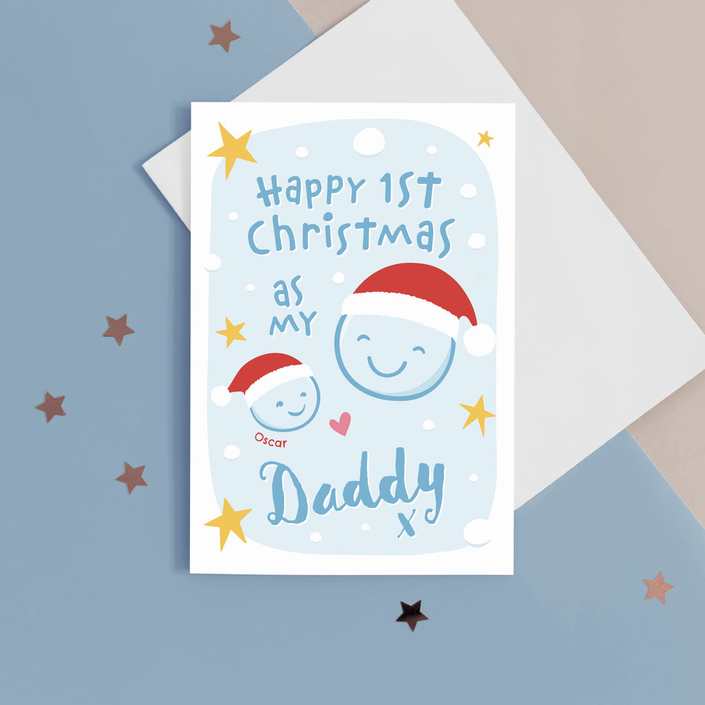 Happy first Christmas as my Daddy. A cute Christmas card featuring two smiling faces in santa hats against a snowy background with blue text. Includes babies name.