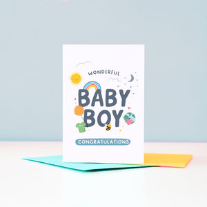 Wonderful Baby Boy Congratulations. A cute and colourful card featuring mini illustrations of a sunshine, rainbow, moon, stars, world holding a heart, balloon, tshirt and bee.