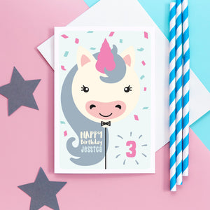 Happy birthday card with cute unicorn balloon design. This card can be personalised with any name and age. Pink, white and grey