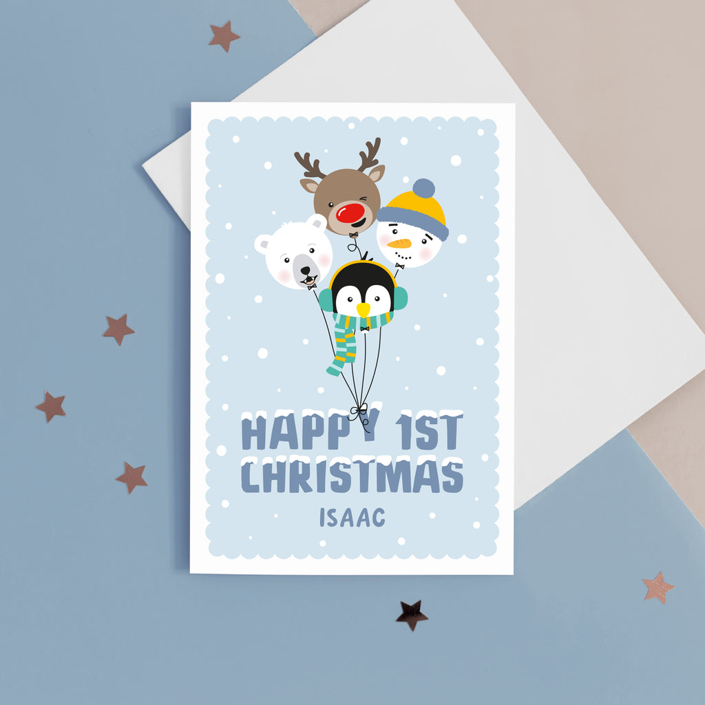 A super cute Christmas card featuring a bunch of happy balloon animals - reindeer, polar bear, penguin and snowman on a soft blue background. Featuring the words Happy 1st Christmas with a space for personalising the card.