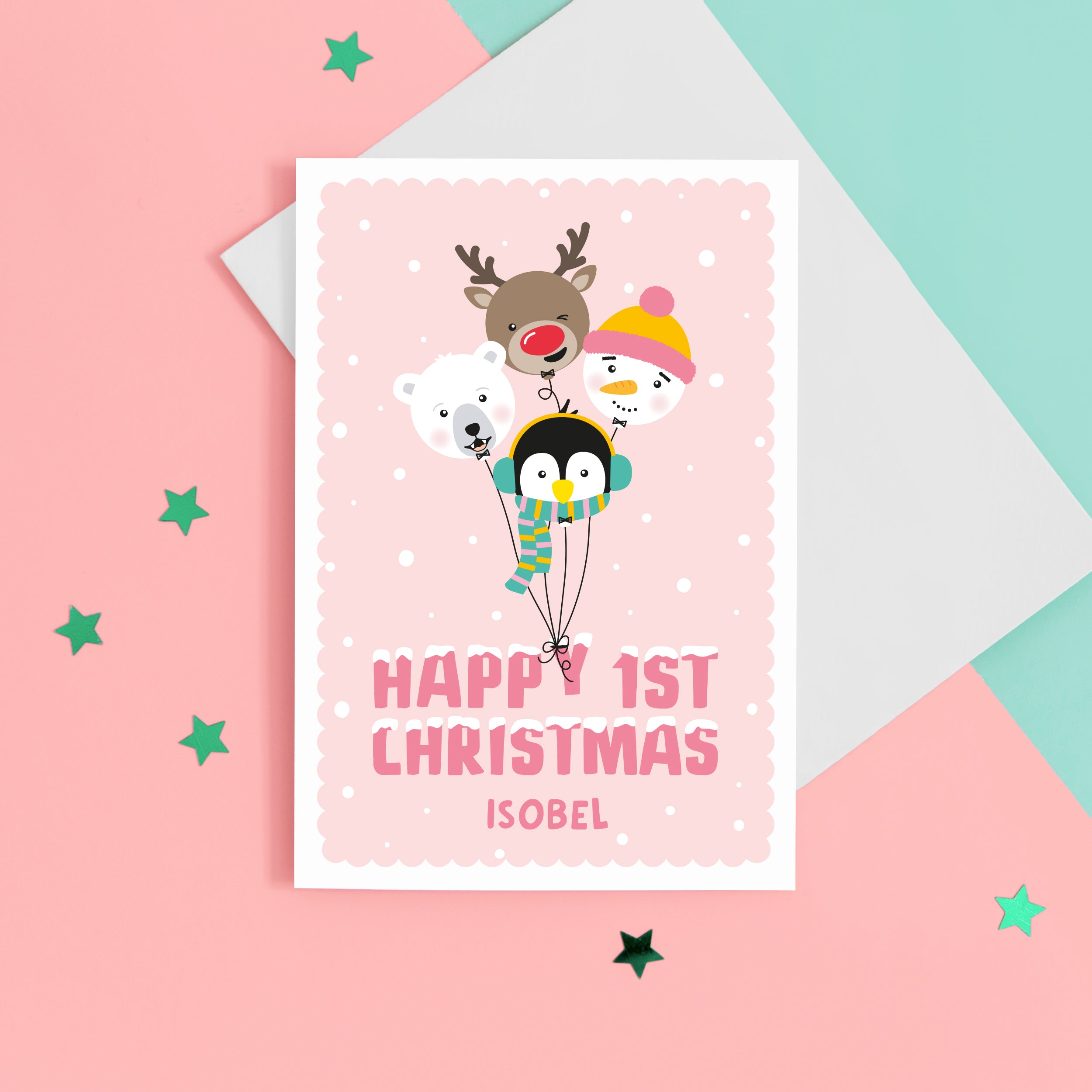 A super cute Christmas card featuring a bunch of happy balloon animals - reindeer, polar bear, penguin and snowman on a soft pink background. Featuring the words Happy 1st Christmas with a space for personalising the card.