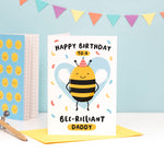 Load image into Gallery viewer, Happy birthday to a bee-rilliant Daddy. A cute and punny card featuring a happy bee wearing a party hat to represent Daddy, with a light blue heart in the background and a sprinkle of confetti.
