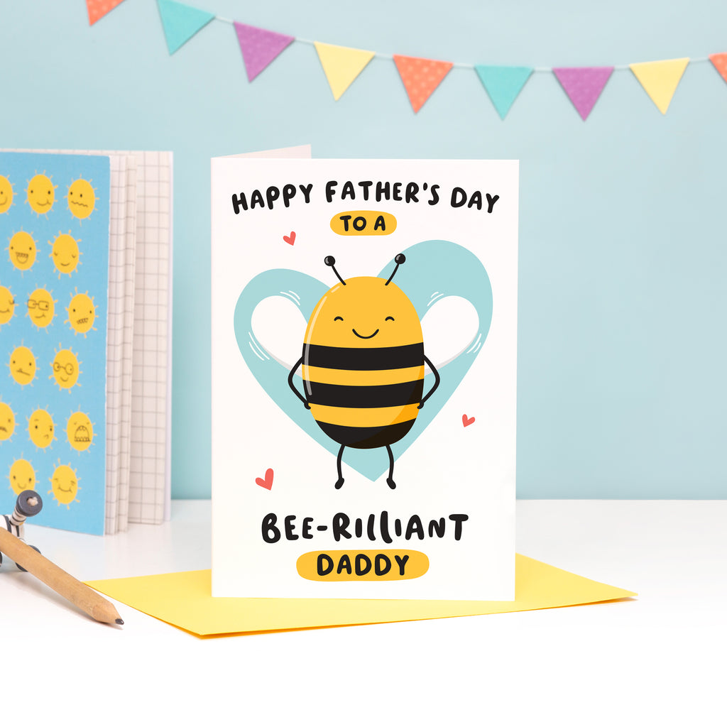 Happy Father's Day to a bee-rilliant Daddy. A cute and punny card featuring a happy bee to represent Daddy, with a light blue heart in the background.