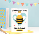 Load image into Gallery viewer, Happy Father&#39;s Day to a bee-rilliant Daddy. A cute and punny card featuring a happy bee to represent Daddy, with a light blue heart in the background.
