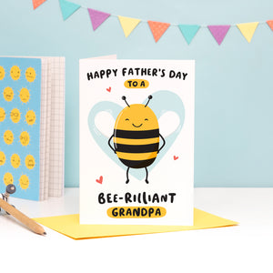 Happy Father's Day to a bee-rilliant Grandpa. A cute and punny card featuring a happy bee to represent Grandpa, with a light blue heart in the background.