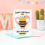 Load image into Gallery viewer, Happy birthday to a bee-rilliant mummy. A cute and punny card featuring a happy bee wearing a party hat to represent mummy, with a pink heart in the background and a sprinkle of confetti.
