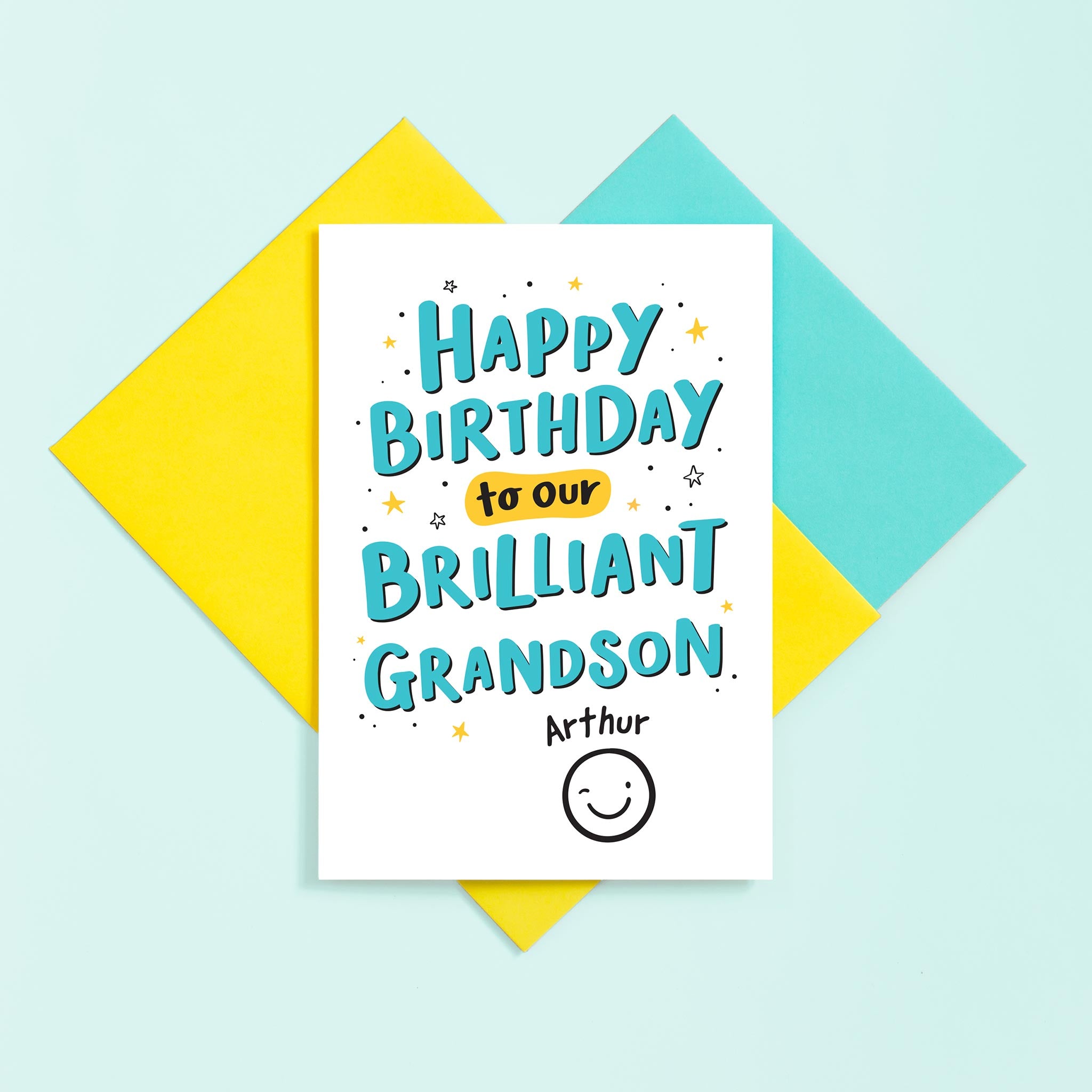 A hand lettered typographic card for a brilliant Grandson. The card features a collection of stars around the text and can be personalised with a name above a winking smiley face.