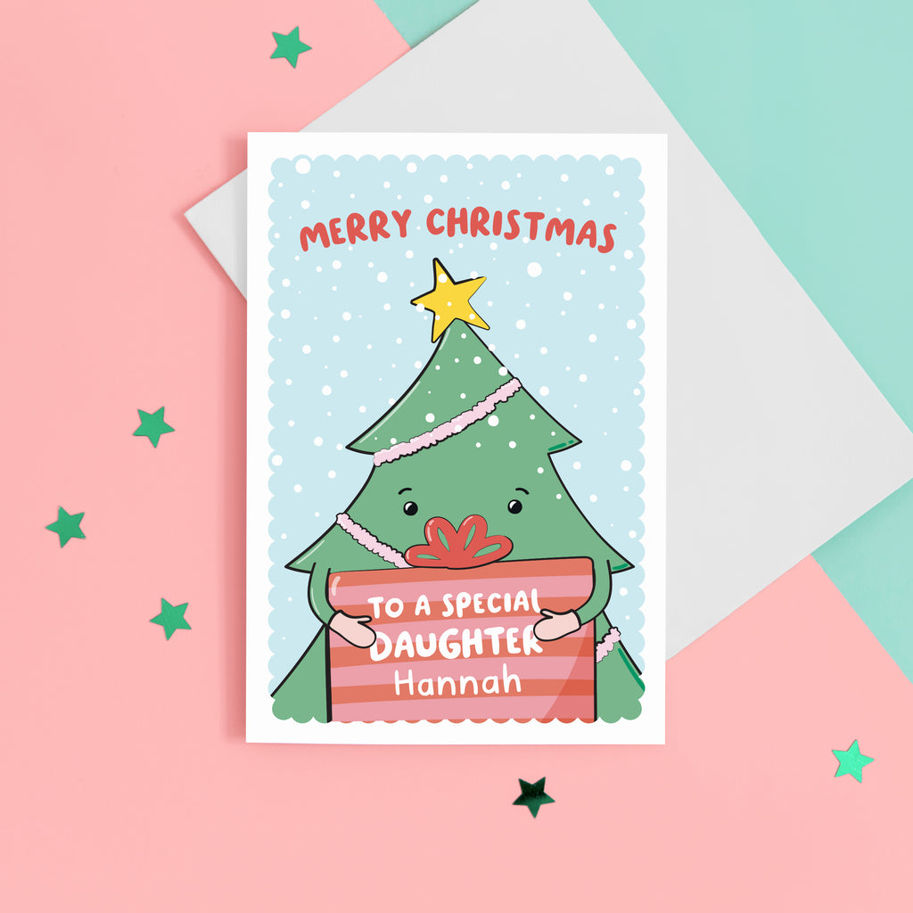 A cute Christmas card with a blue background, featuring a Christmas tree holding a present with a sprinkling of snow. The card reads Merry Christmas to a special Daughter with space to personalise with a name.