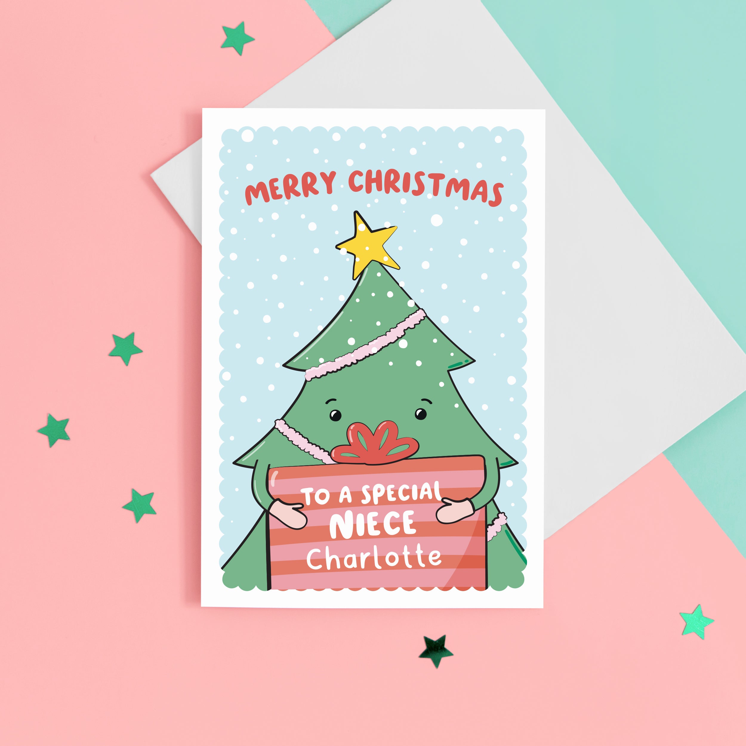 A cute Christmas card with a blue background, featuring a Christmas tree holding a present with a sprinkling of snow. The card reads Merry Christmas to a special Niece with space to personalise with a name.