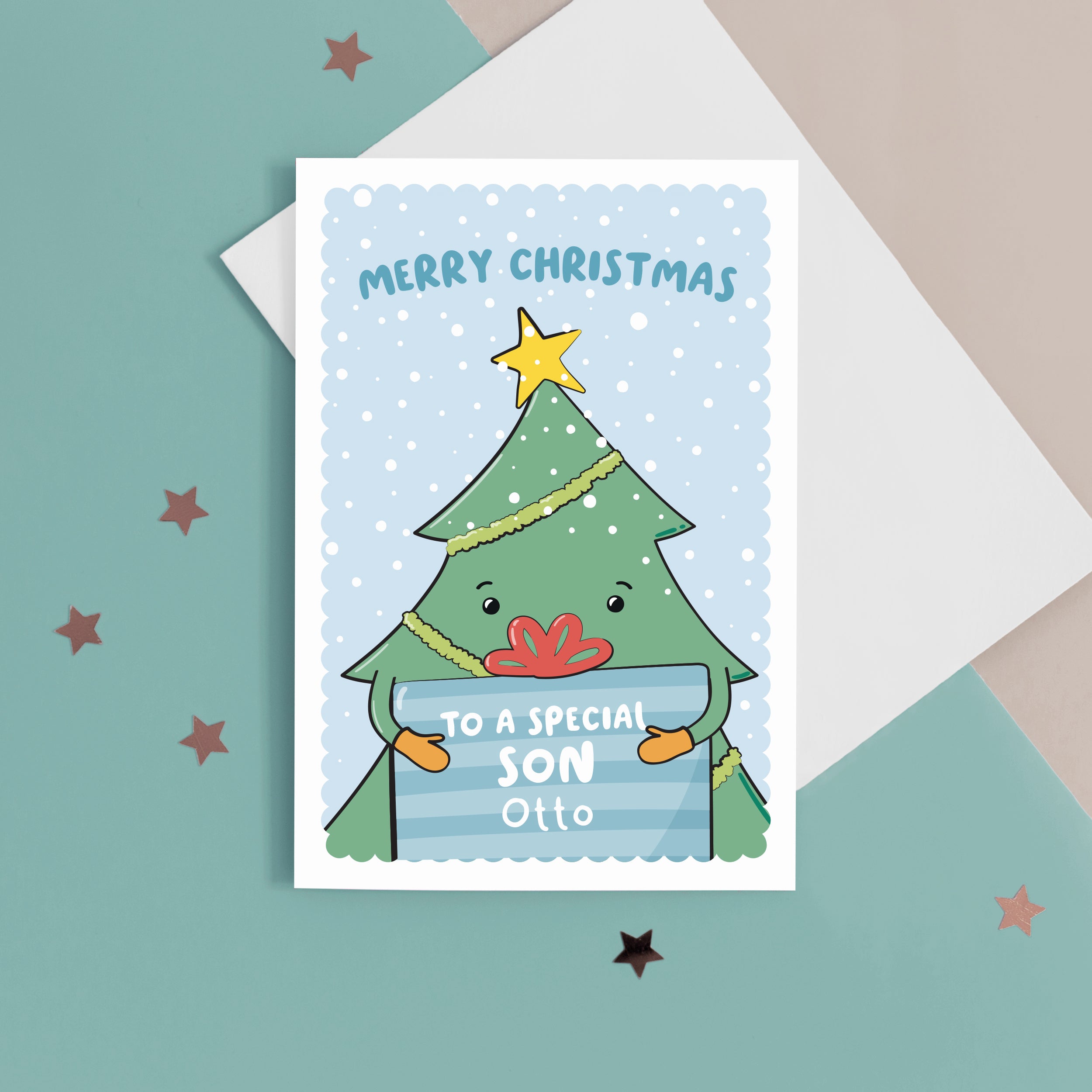 A cute Christmas card with a blue background, featuring a Christmas tree holding a present with a sprinkling of snow. The card reads Merry Christmas to a special Son with space to personalise with a name.