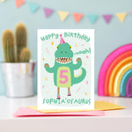 Load image into Gallery viewer, Birthday card with cute girl dressed in a dinosaur costume. Personalised for any name and age, as well age eye colour, skin colour and hair colour. Shown age five.
