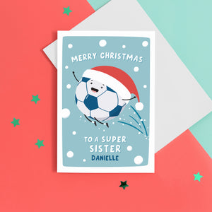 A fun football themed Christmas card featuring a happy football wearing a santa’s hat on a snowy background. The card reads ‘Merry Christmas to a super Sister’ with space underneath to personalise with a name.