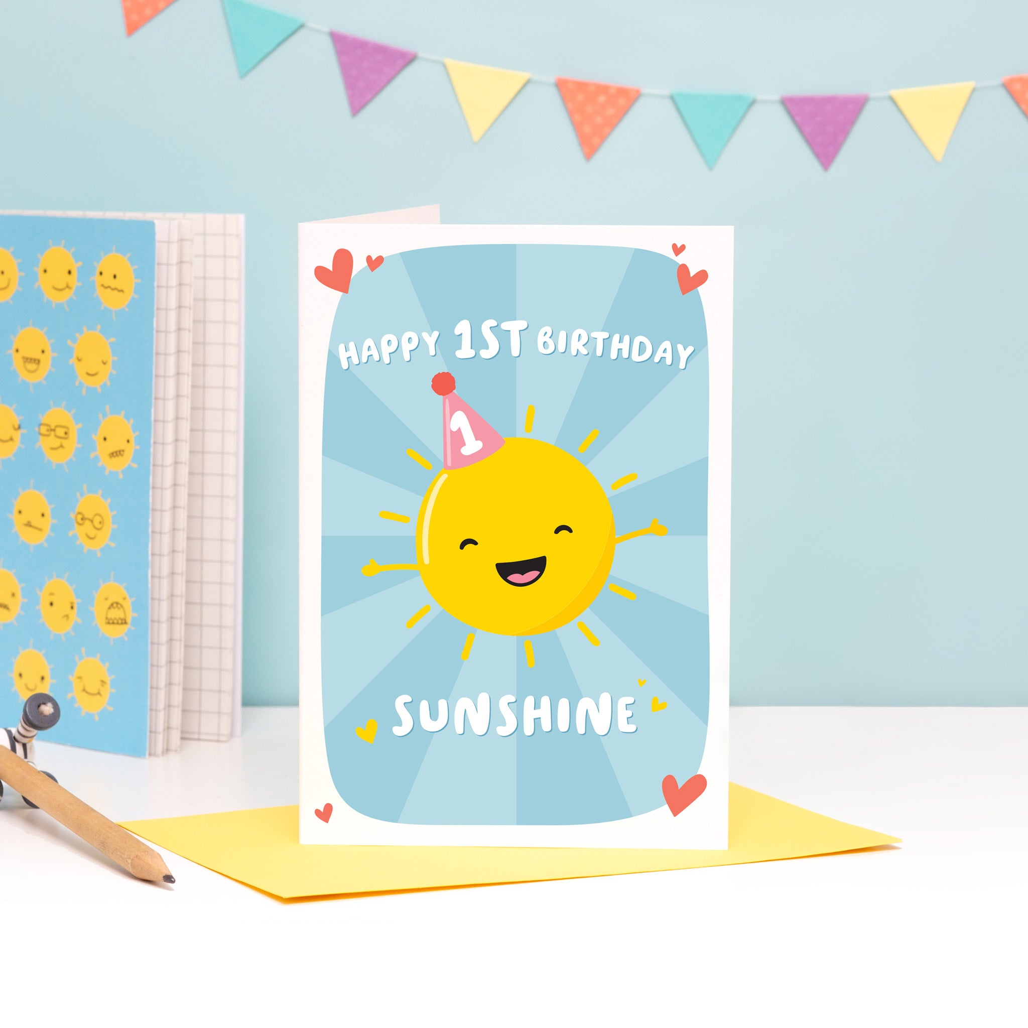 A colourful and fun design featuring a happy sunshine wearing a party hat with the number 1 on it. The card reads’ happy 1st birthday sunshine’. The card has a colourful blue starburst background.