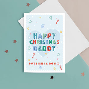 A sweet Christmas card with a light blue background and small hand drawn illustrations of Christmas trees, presents, stars and hearts. The card has snow topped wording in festive colours which reads 'Happy Christmas Daddy'. The bottom of the card can be customised with your own message.