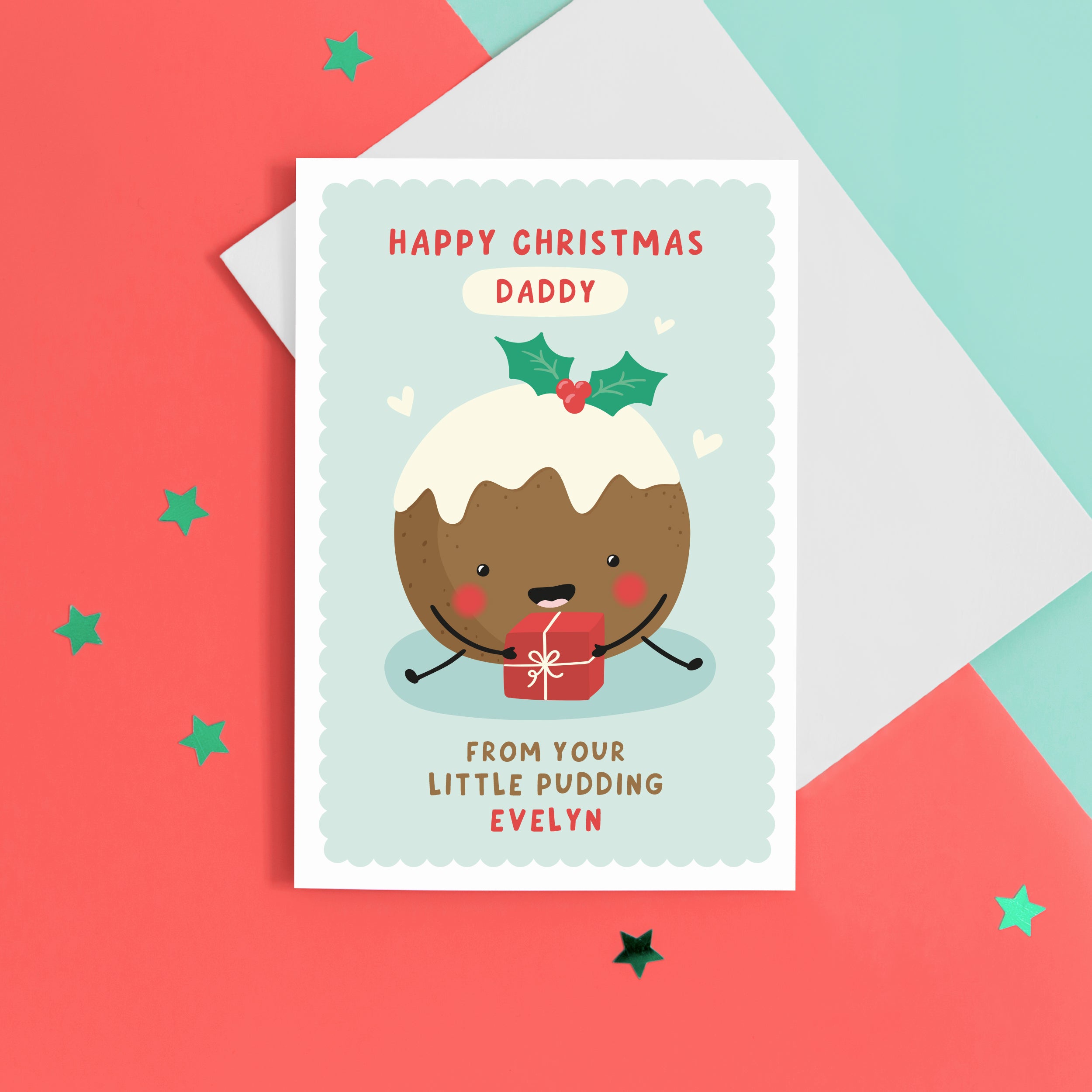 A super cute card featuring a happy little Christmas pudding illustration, holding a present. The card reads 'Happy Christmas Daddy from your little pudding', with space to personalise with the baby's name.