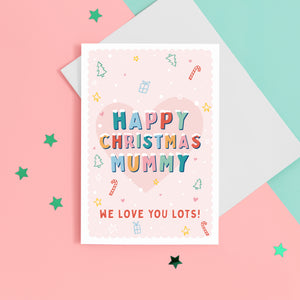 A sweet Christmas card with a pink background and small handrawn illustrations of Christmas trees, presents, stars and hearts. The card details colourful snowtopped wording reading Happy Christmas Mummy. The bottom of the card can be customised with your own message.