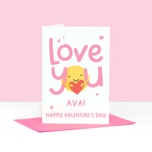 A super cute valentines card with the words 'love you' in pink and featuring a sunshine hug holding a heart. This card can be personalised with a name.