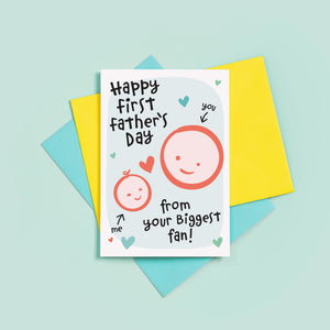 Happy first Father's day - from your biggest fan. This sweet Father's day card features smiling father and child faces with hearts against a turquoise background.