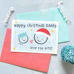 Load image into Gallery viewer, Happy Christmas Daddy, love you lots. Cute Christmas card featuring 2 faces representing father and child. The smaller face wears a Christmas party hat and a larger face a santa hat. The card is personalised with the child&#39;s name and has a soft blue background.
