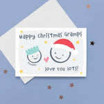 Load image into Gallery viewer, Happy Christmas Gramps, love you lots. Cute Christmas card featuring 2 faces representing Grandfather and Grandchild. The smaller face wears a Christmas party hat and a larger face a santa hat. The card is personalised with the child&#39;s name and has a soft grey background.
