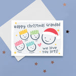 Load image into Gallery viewer, Happy Christmas Grandad, we love you lots. Cute Christmas card featuring 5 faces representing Grandfather and 4 grandchildren. The smaller faces wear Christmas party hats and the larger face a santa hat. The card is personalised with the children&#39;s names and has a soft grey background.
