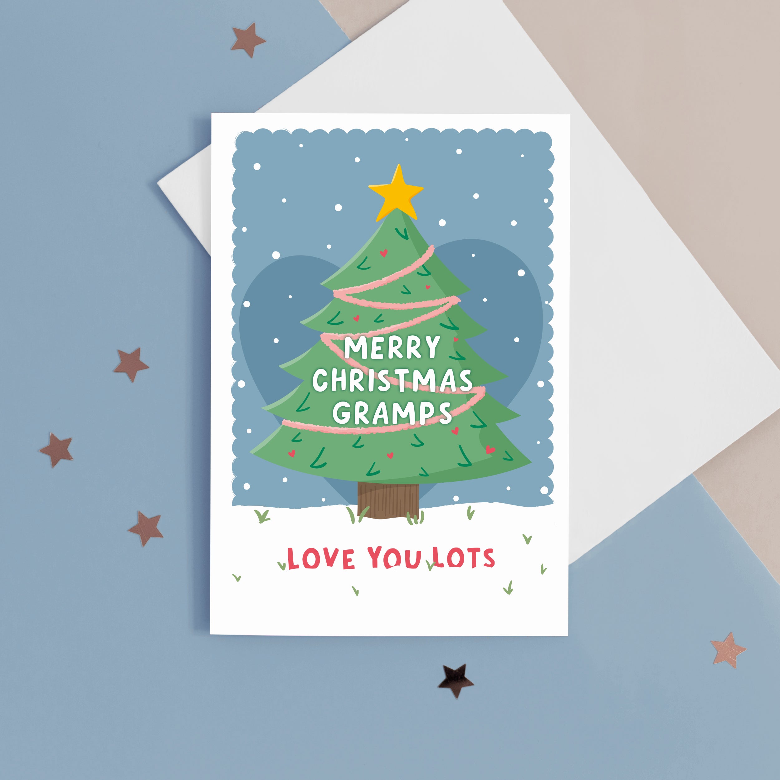 Merry Christmas Grandad. Love you lots. A beautiful Christmas card with a festive tree, star and love hearts on a snowy background in blue. The card can be name customised for Grandad and can include the grandchild’s name(s) at the bottom.