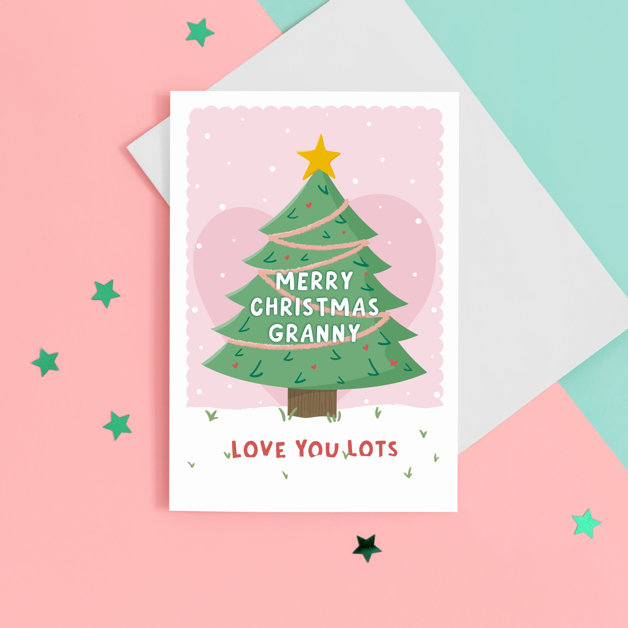 Merry Christmas Grandma. Love you lots. A beautiful Christmas card with a festive tree, star and love hearts on a snowy background in pink. The card can be name customised for Grandma and can include the grandchild’s name(s) at the bottom.