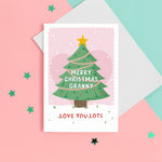 Load image into Gallery viewer, Merry Christmas Grandma. Love you lots. A beautiful Christmas card with a festive tree, star and love hearts on a snowy background in pink. The card can be name customised for Grandma and can include the grandchild’s name(s) at the bottom.
