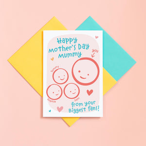 A cute Mother's day card for Mummy from her biggest fans. This card features a smiling face representing Mummy and 3 children's faces which can be personalised with their names. The background of the card is light pink and includes a collection of hearts around the design.