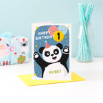 Load image into Gallery viewer, A fun and colourful card featuring a happy panda wearing a party hat, a collection of smiling balloons and a pop of confetti. There is space on a balloon to detail the childs age and there is space to personalise the card with a name on the pandas tummy.
