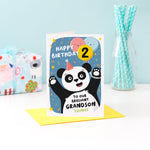 Load image into Gallery viewer, A fun and colourful card featuring a happy panda wearing a party hat, a collection of smiling balloons and a pop of confetti. The card reads happy birthday to our brilliant grandson with space to personalise with a name. There is also space on a balloon to add the childs age.
