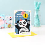 Load image into Gallery viewer, A fun and colourful card featuring a happy panda wearing a party hat, a collection of smiling balloons and a pop of confetti. The card reads happy birthday to my brilliant grandson with space to personalise with a name. There is also space on a balloon to add the childs age.
