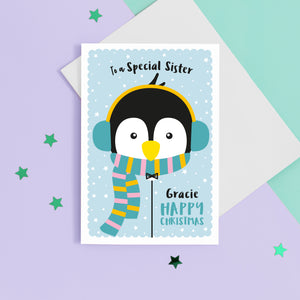 Happy christmas to a special Sister. A cute personalised Christmas card featuring a penguin in snow wrapped up with earmuffs and scarf. Add any name and personal greeting to this card.