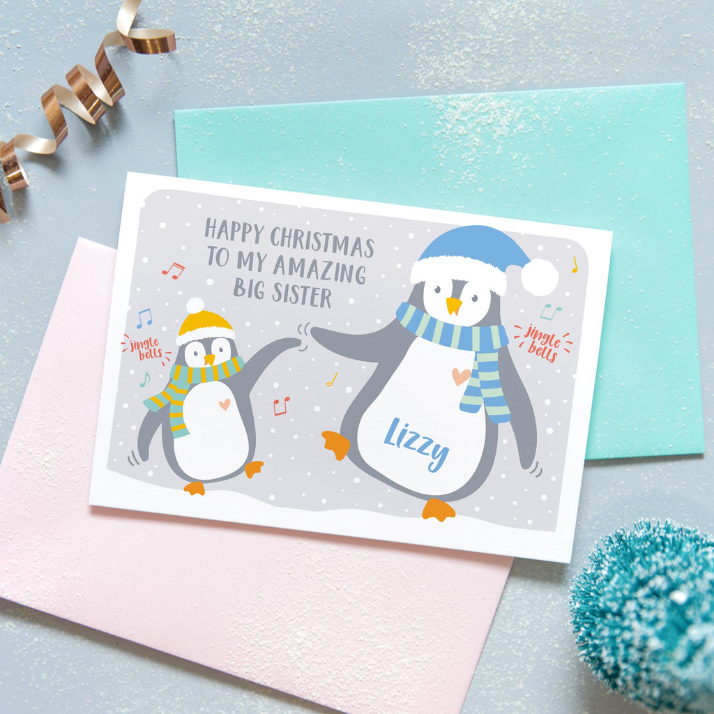 Happy Christmas to my amazing big sister. A cute personalised birthday card featuring a little penguin and a big penguin wearing scarves and hats and dancing. each penguin can be named to represent the sender and recipient