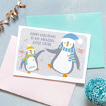 Load image into Gallery viewer, Happy Christmas to my amazing little sister. A cute personalised birthday card featuring a little penguin and a big penguin wearing scarves and hats and dancing. each penguin can be named to represent the sender and recipient
