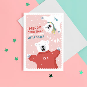 A fun Christmas card featuring two polar bears on a pink snowy background. The card reads ‘Merry Christmas to my roarsome little Sister’. The polar bears can be personalised with names to represent siblings.