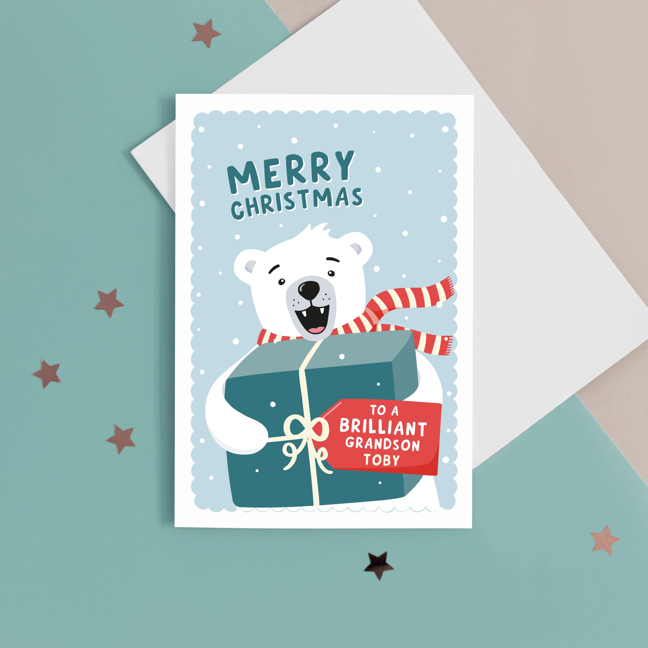 A fun Christmas card featuring a polar bear holding a big present with a tag for personalisation. T The card reads ‘Merry Christmas to a Brilliant Grandson’. The card can be personalised for any recipient .