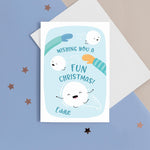 Load image into Gallery viewer, A fun Christmas card featuring two arms throwing happy snowballs with faces and the words &#39;wishing you a fun Christmas&#39;. The card has a blue colourway and can be personalised with the recipients name.
