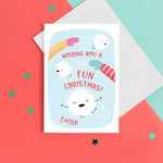 Load image into Gallery viewer, A fun Christmas card featuring two arms throwing happy snowballs with faces and the words &#39;wishing you a fun Christmas&#39;. The card has a red and blue colourway and can be personalised with the recipients name.
